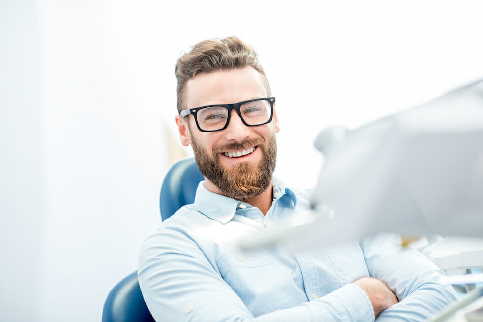man with glass smiling at dentist