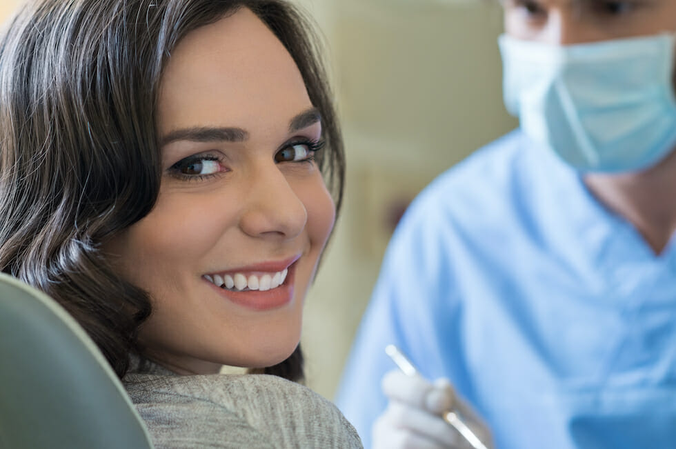 woman smiling with dentist in background