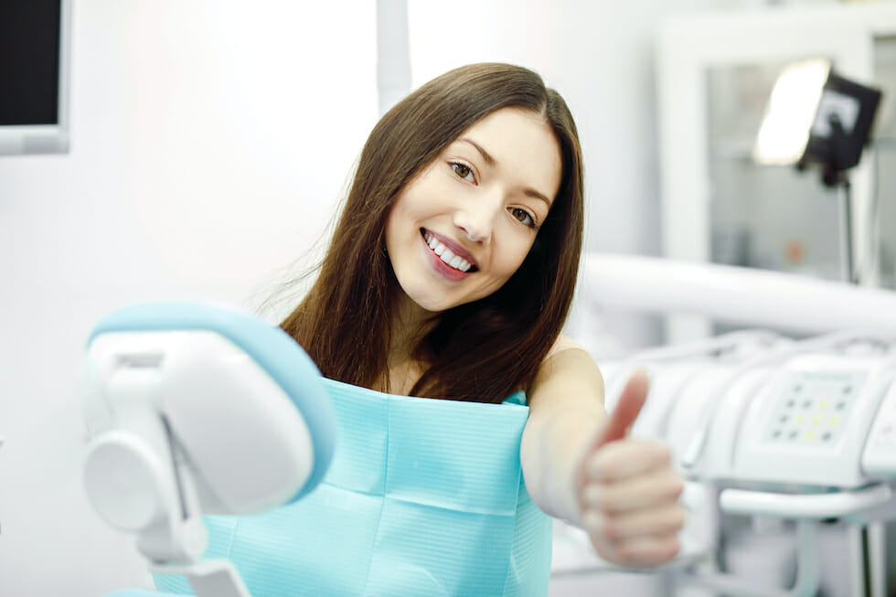 woman at the dentist with thumb up